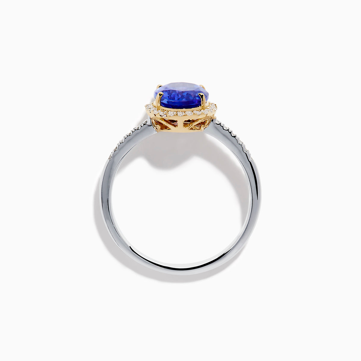 The Nahla 14K Two Tone Gold Tanzanite and Diamond Halo Ring features an oval blue tanzanite center, encircled by a diamond halo and diamond-accented band, all set in elegant two-tone 14K gold.