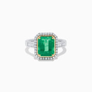 The Brasilica 14K Two Tone Gold Emerald and Diamond Ring showcases a large rectangular green emerald in a gold prong setting, accented by a halo of clear diamonds and baguette-cut diamonds along the band.