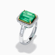 The Brasilica 14K Two Tone Gold Emerald and Diamond Ring showcases a large rectangular green emerald in a gold prong setting, accented by a halo of clear diamonds and baguette-cut diamonds along the band.