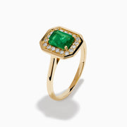 The Brasilica 14K Yellow Gold Emerald and Diamond Ring showcases a rectangular green emerald center, surrounded by a halo of sparkling round white diamonds, all set in yellow gold and displayed on a white background.