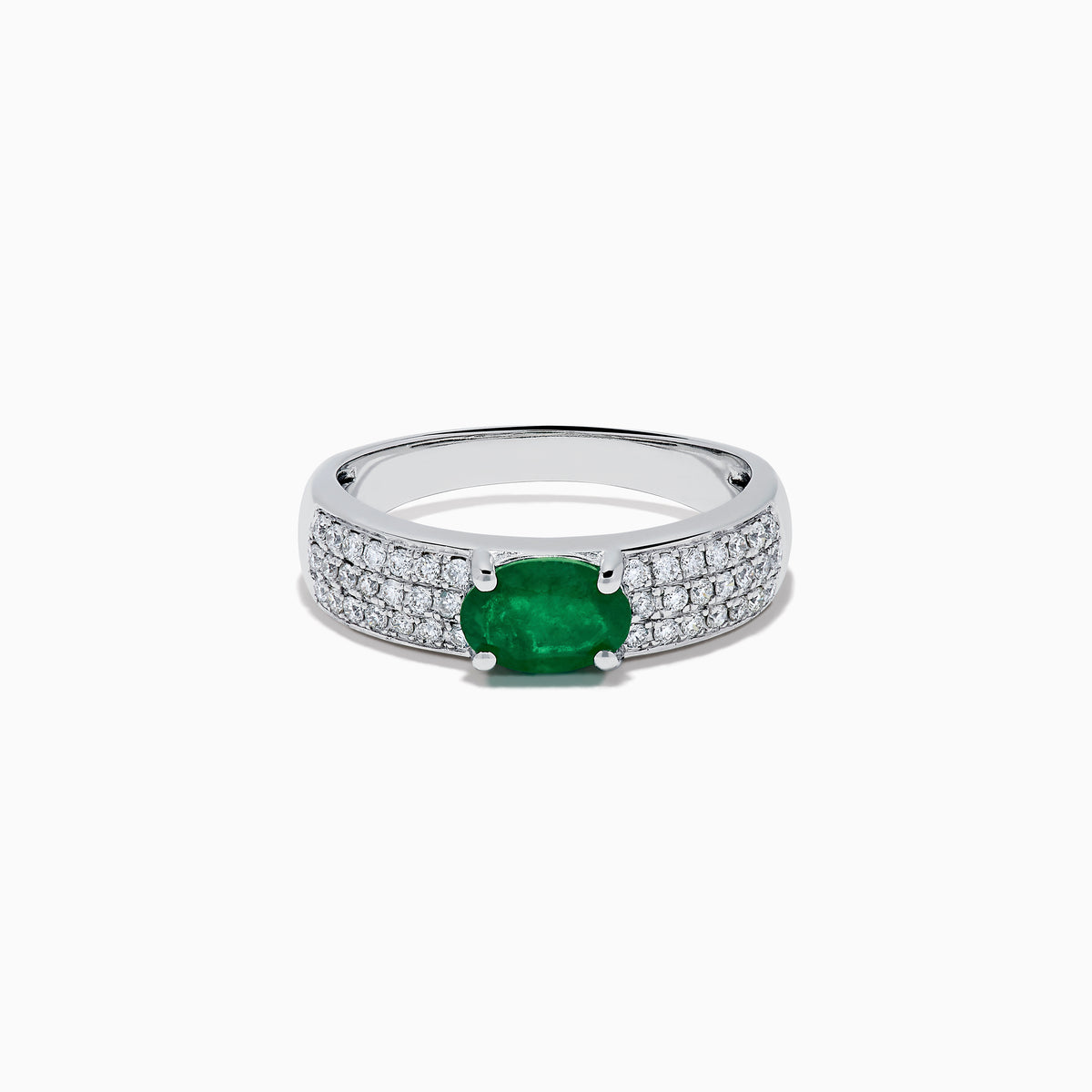 The Brasilica 14K White Gold Emerald and Diamond Ring showcases a central oval green emerald with three rows of round diamonds on each side, set in white gold and shown against a white background.