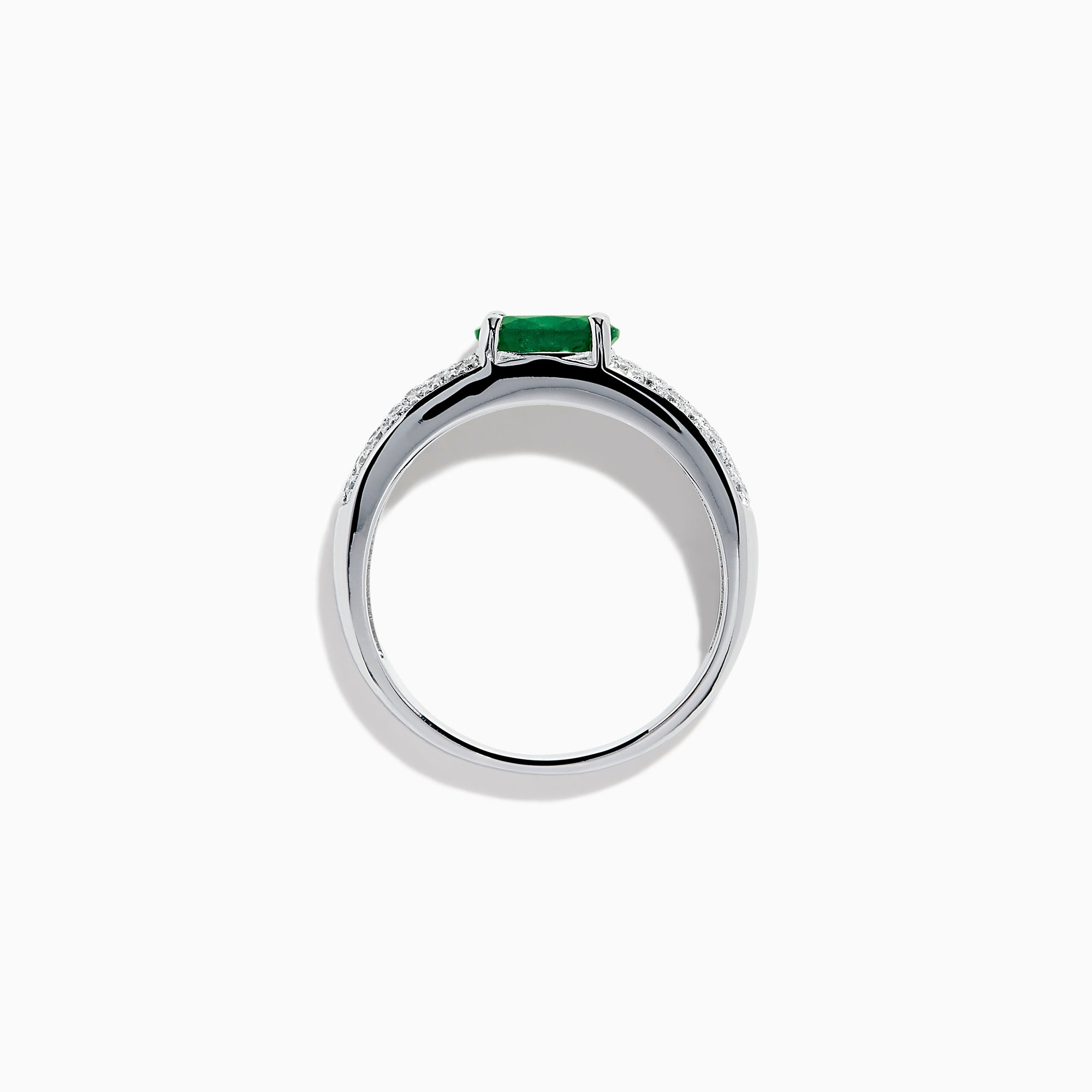The Brasilica 14K White Gold Emerald and Diamond Ring showcases a central oval green emerald with three rows of round diamonds on each side, set in white gold and shown against a white background.