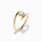 The 14K Yellow Gold Channel Set Diamond Bouquet Ring features a central round-cut diamond and channel set diamonds in a halo on an open band, shown on a white background.