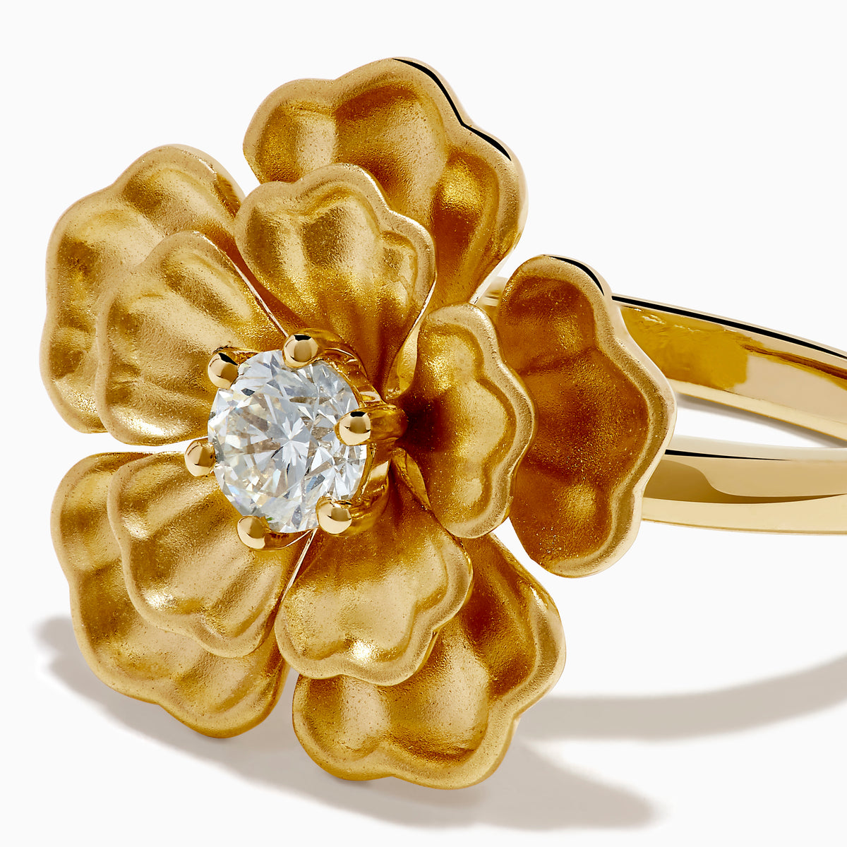 The 14K Yellow Gold Diamond Sculpted Flower Ring features five textured petals and a sparkling round diamond at the center, displayed on a white background.
