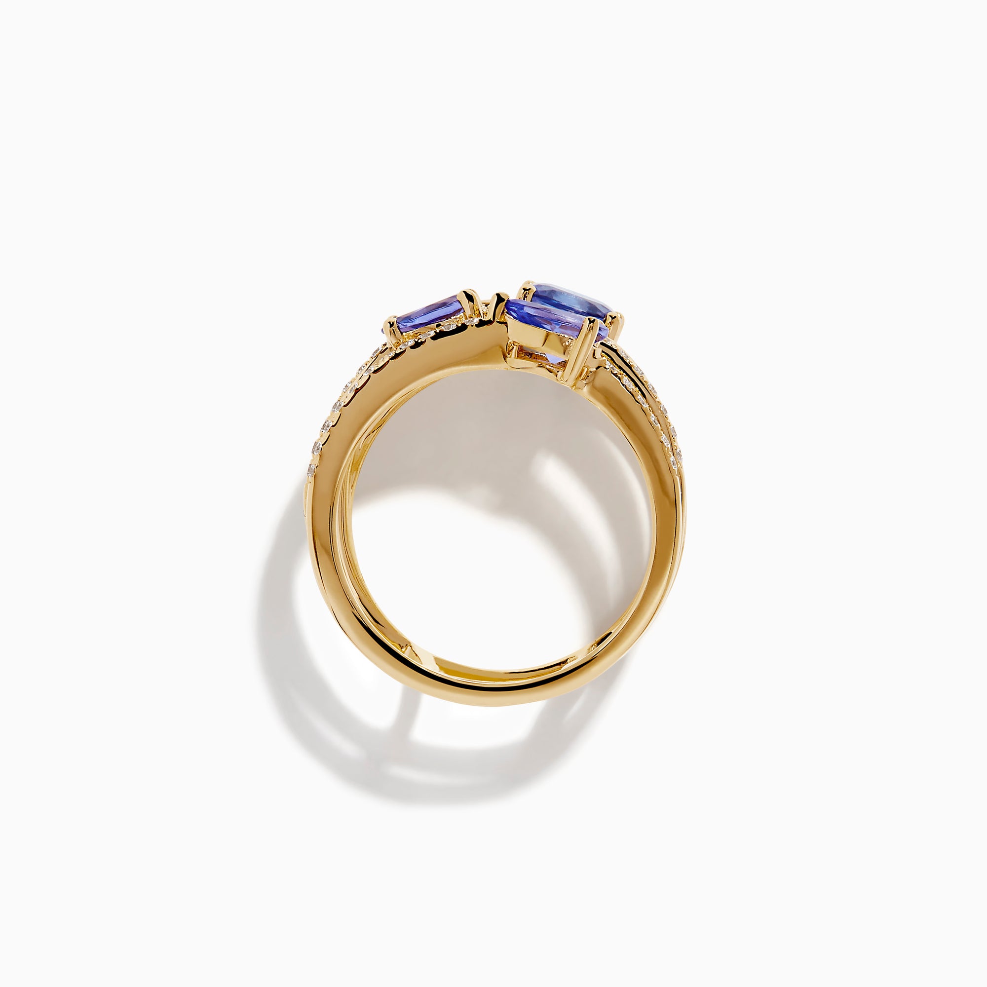 The 14K Yellow Gold Tanzanite and Diamond Multi-Row Statement Ring features three stacked bands set with white diamonds and pear, oval, and cushion-cut blue tanzanite gemstones.