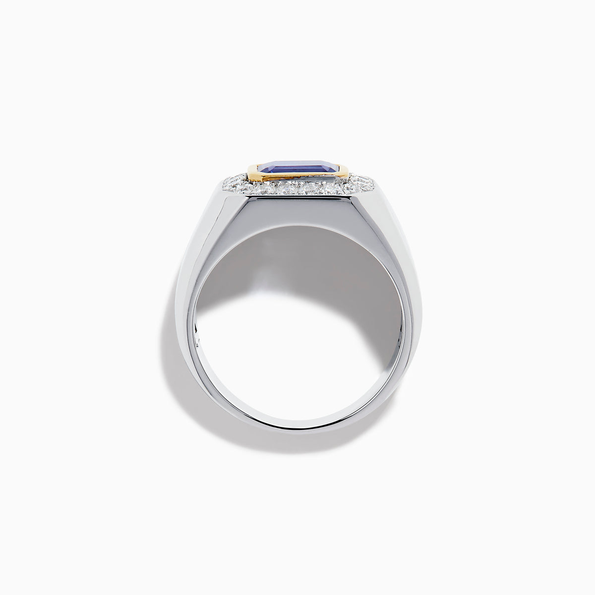 The Men's 14K Two Tone Gold East West Emerald Cut Tanzanite and Diamond Ring features a rectangular blue tanzanite set in a gold bezel, framed by white diamonds, all beautifully crafted against a plain white background.