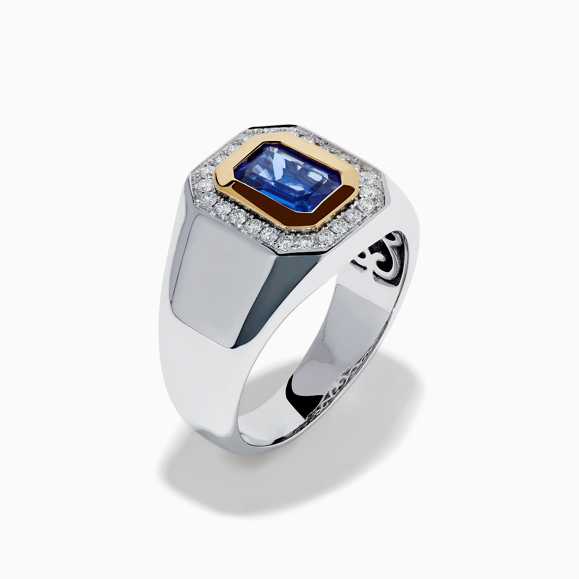 The Men's 14K Two Tone Gold Tanzanite and Diamond Bezel Halo Ring features a rectangular blue tanzanite framed by dazzling white diamonds, set on a bold band for a standout look.
