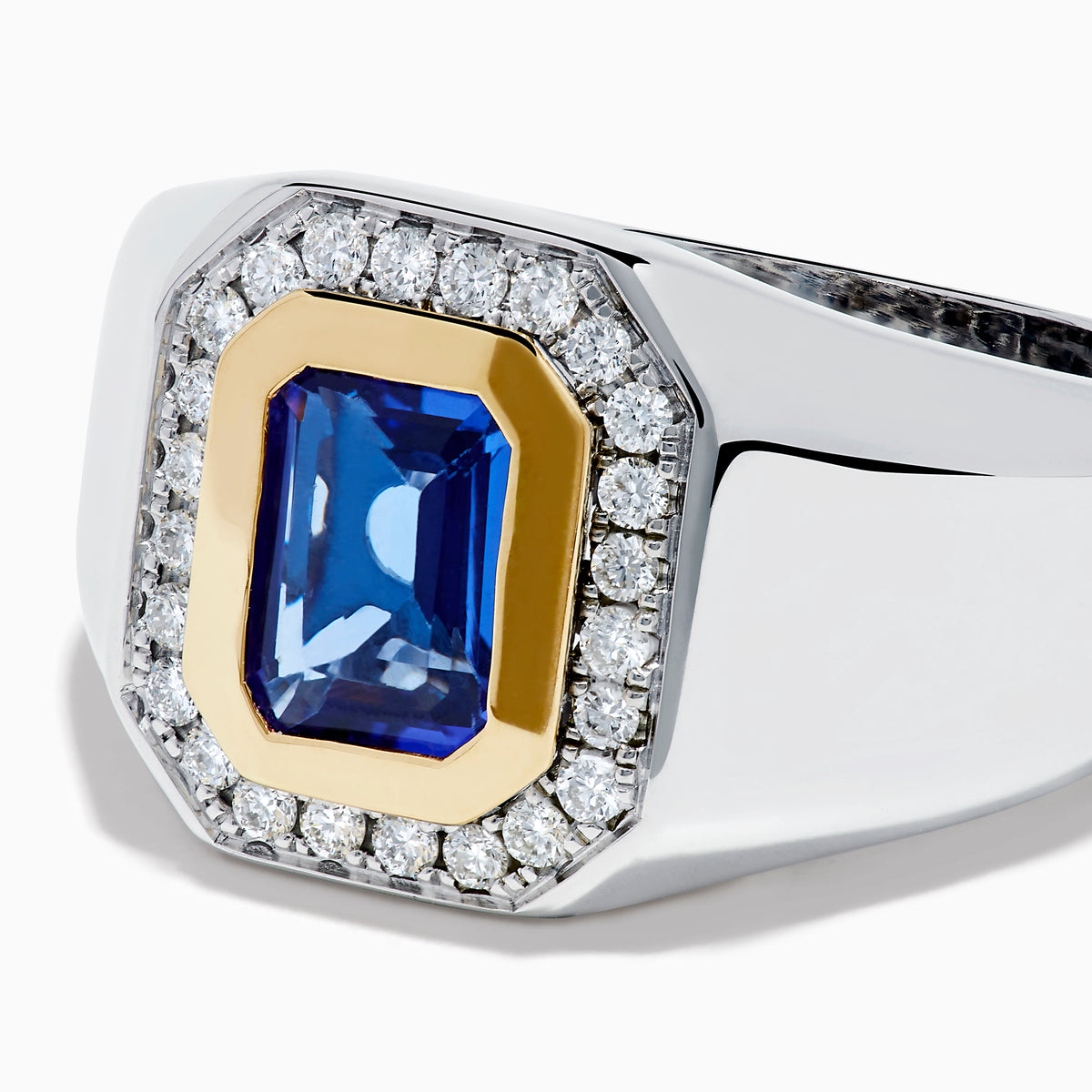 The Men's 14K Two Tone Gold Tanzanite and Diamond Bezel Halo Ring features a rectangular blue tanzanite framed by dazzling white diamonds, set on a bold band for a standout look.