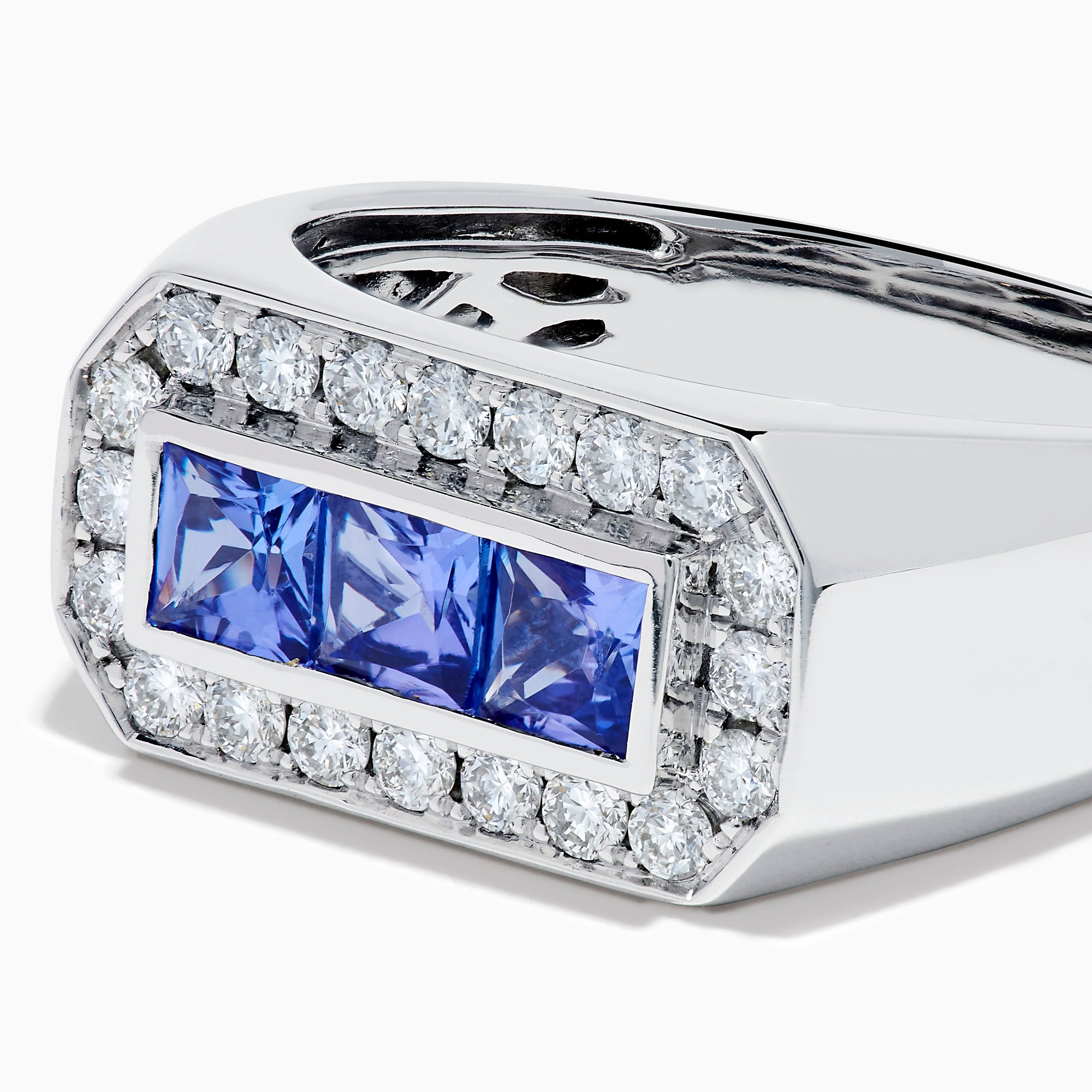 The Men's 14K White Gold Princess Cut Tanzanite and Diamond Signet Ring features three princess-cut tanzanites at the center, framed by small round white diamonds in an octagonal border.