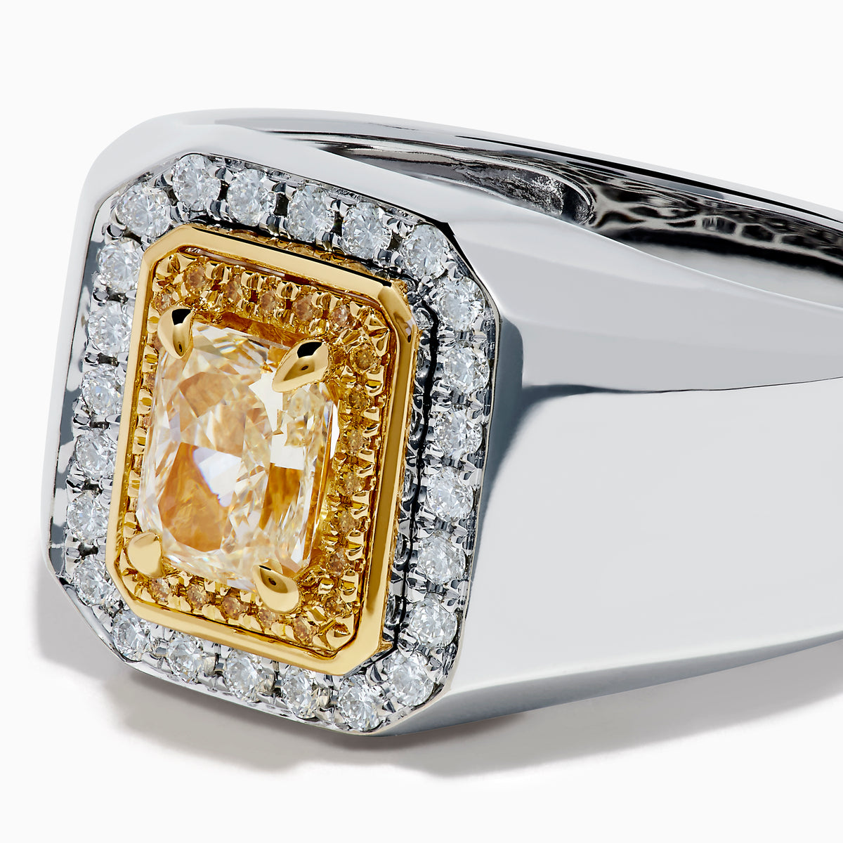 The Men's 18K Two Tone Yellow and White Diamond Ring features a rectangular yellow gemstone at its center, surrounded by double halos of white stones and yellow-gold details, shown on a white background.