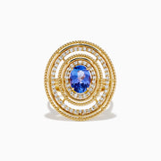 The 14K Yellow Gold Tanzanite and Diamond Concentric Halo Ring showcases concentric circular diamond bands with a central oval tanzanite gemstone, elegantly presented on a white background.