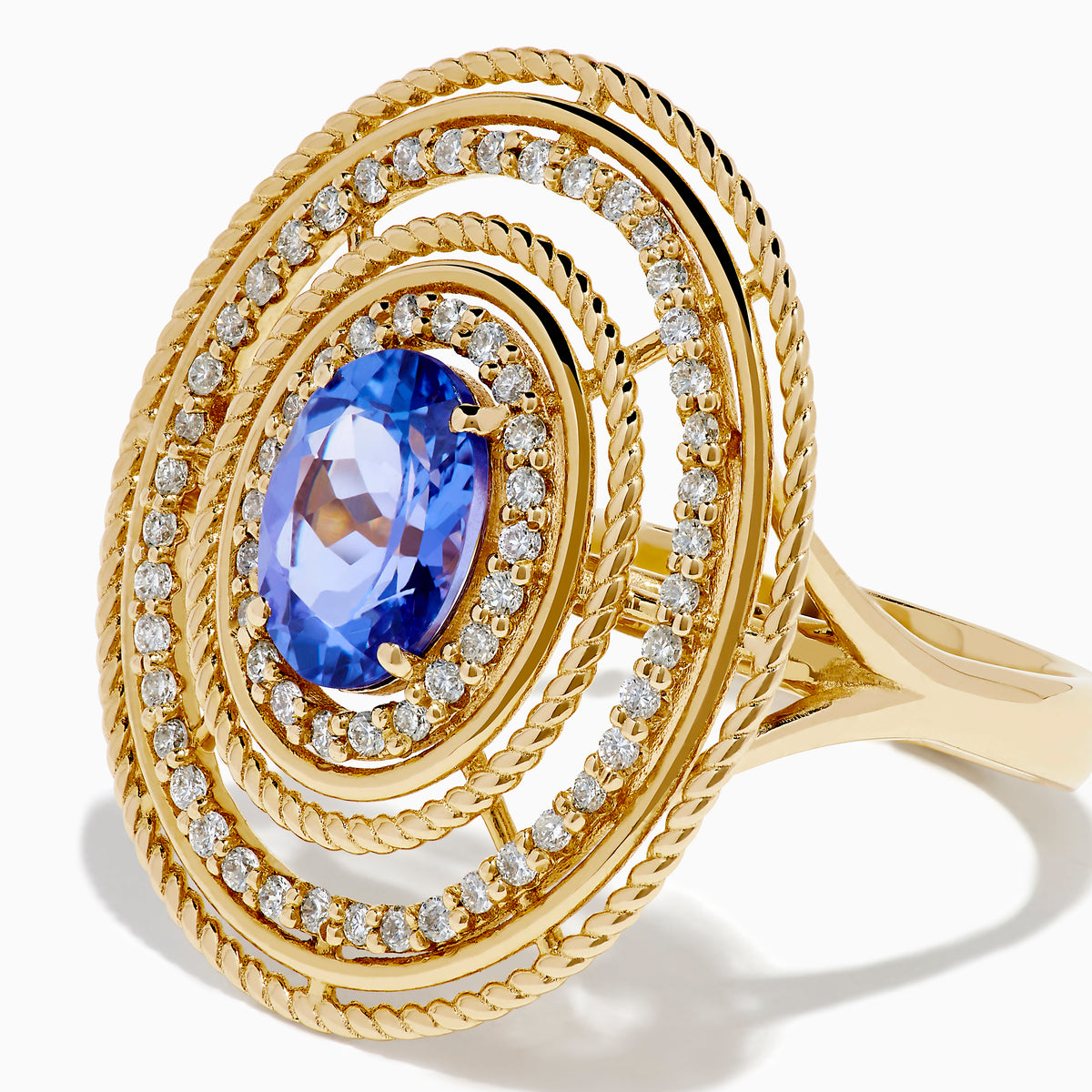 The 14K Yellow Gold Tanzanite and Diamond Concentric Halo Ring showcases concentric circular diamond bands with a central oval tanzanite gemstone, elegantly presented on a white background.