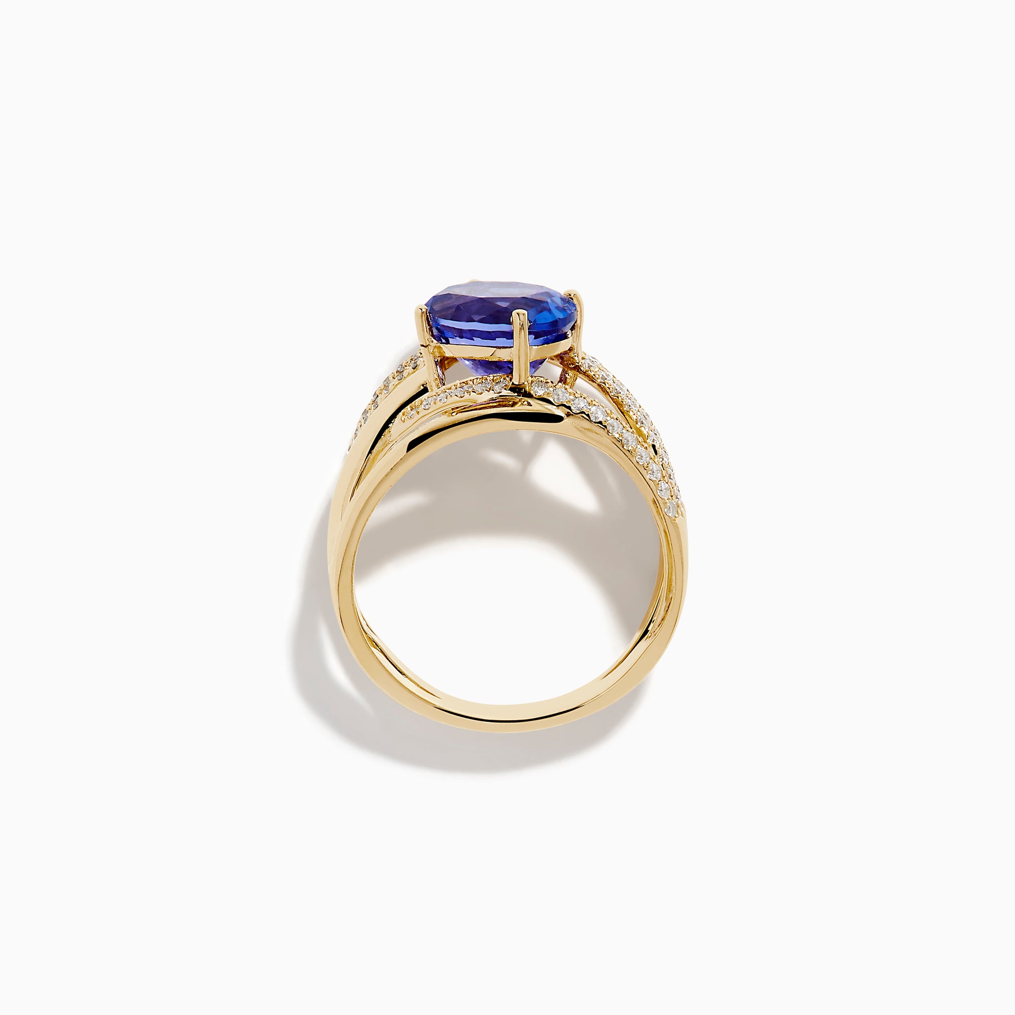The 14K Yellow Gold Tanzanite and Diamond Crossover Ring showcases an oval tanzanite center stone accented by intersecting diamond-encrusted bands for a brilliant, modern look.