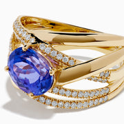The 14K Yellow Gold Tanzanite and Diamond Crossover Ring showcases an oval tanzanite center stone accented by intersecting diamond-encrusted bands for a brilliant, modern look.