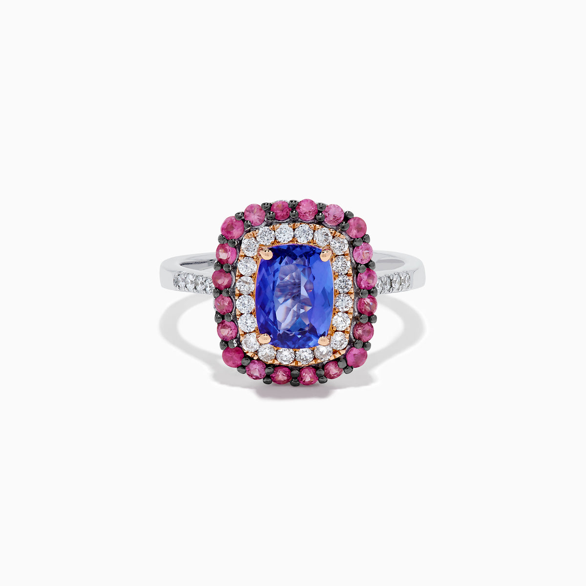 The 14K Two Tone Gold Tanzanite, Diamond, and Pink Sapphire Cushion Halo Ring features a striking tanzanite center, framed by sparkling diamonds and a halo of vivid pink sapphires on a sleek white background.