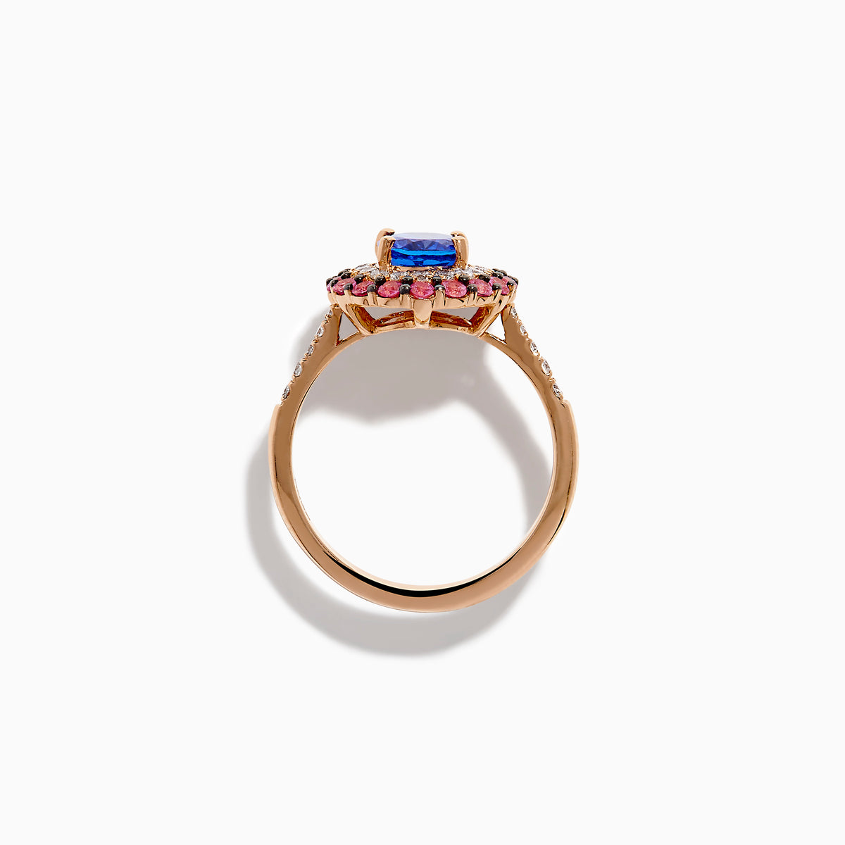 The 14K Rose Gold Tanzanite, Diamond, and Pink Sapphire Oval Halo Ring features a large oval blue tanzanite center, double halos of white diamonds and pink sapphires, plus diamond accents on the band.