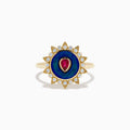 The 14K Yellow Gold Ruby, Diamond, and Enamel Ring showcases a central teardrop ruby, a blue enamel circle, and an outer border of round diamonds in a sunburst design.