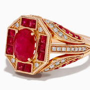 The 14K Rose Gold Ruby and Diamond Art Deco Ring features an oval ruby center, surrounded by square and rectangular rubies and small white diamonds in a geometric, ornate rose gold setting.