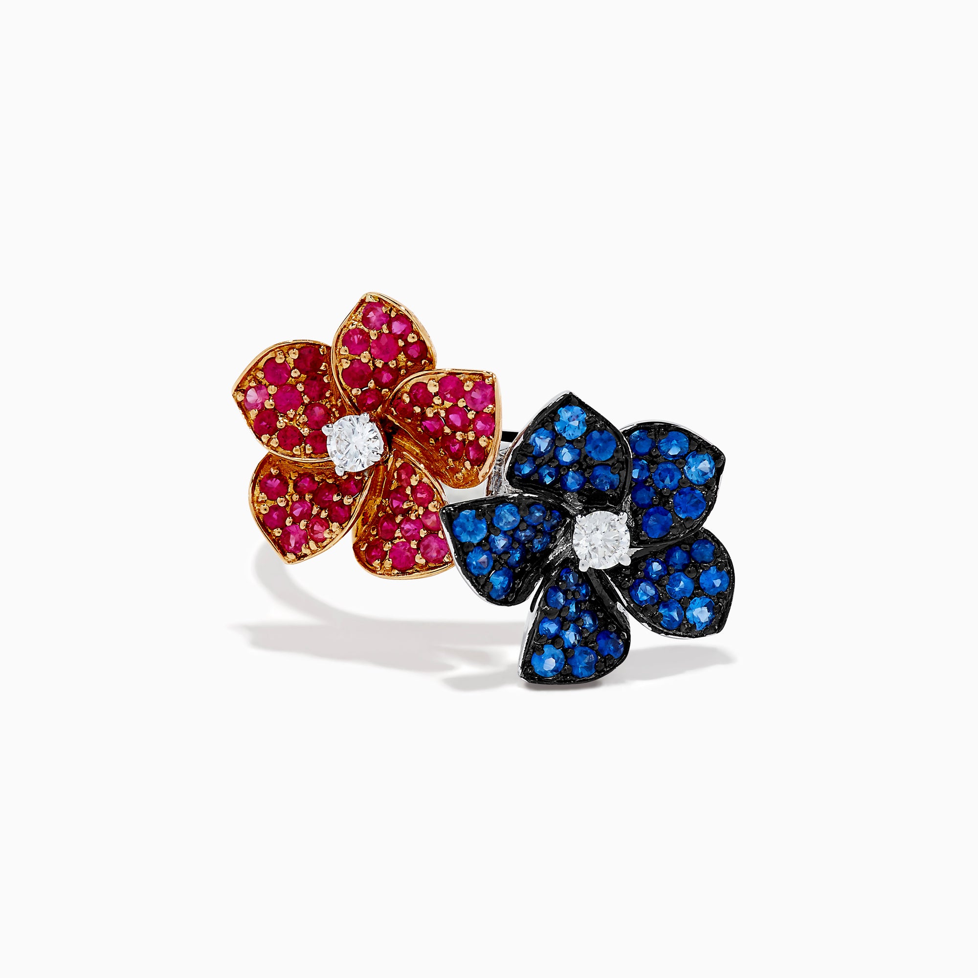 The 14K Two Tone Ruby, Sapphire, and Diamond Floral Bypass Ring features jeweled floral designs with ruby, sapphire, and diamond accents, displayed elegantly on a white background.