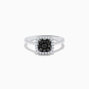 The 14K White Gold White and Black Diamond Ring features a square cluster of black diamonds at the center, bordered by small white gemstones on a sleek band, shown against a white background.