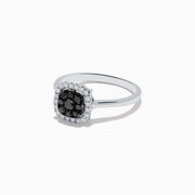 The 14K White Gold White and Black Diamond Ring features a square cluster of black diamonds at the center, bordered by small white gemstones on a sleek band, shown against a white background.