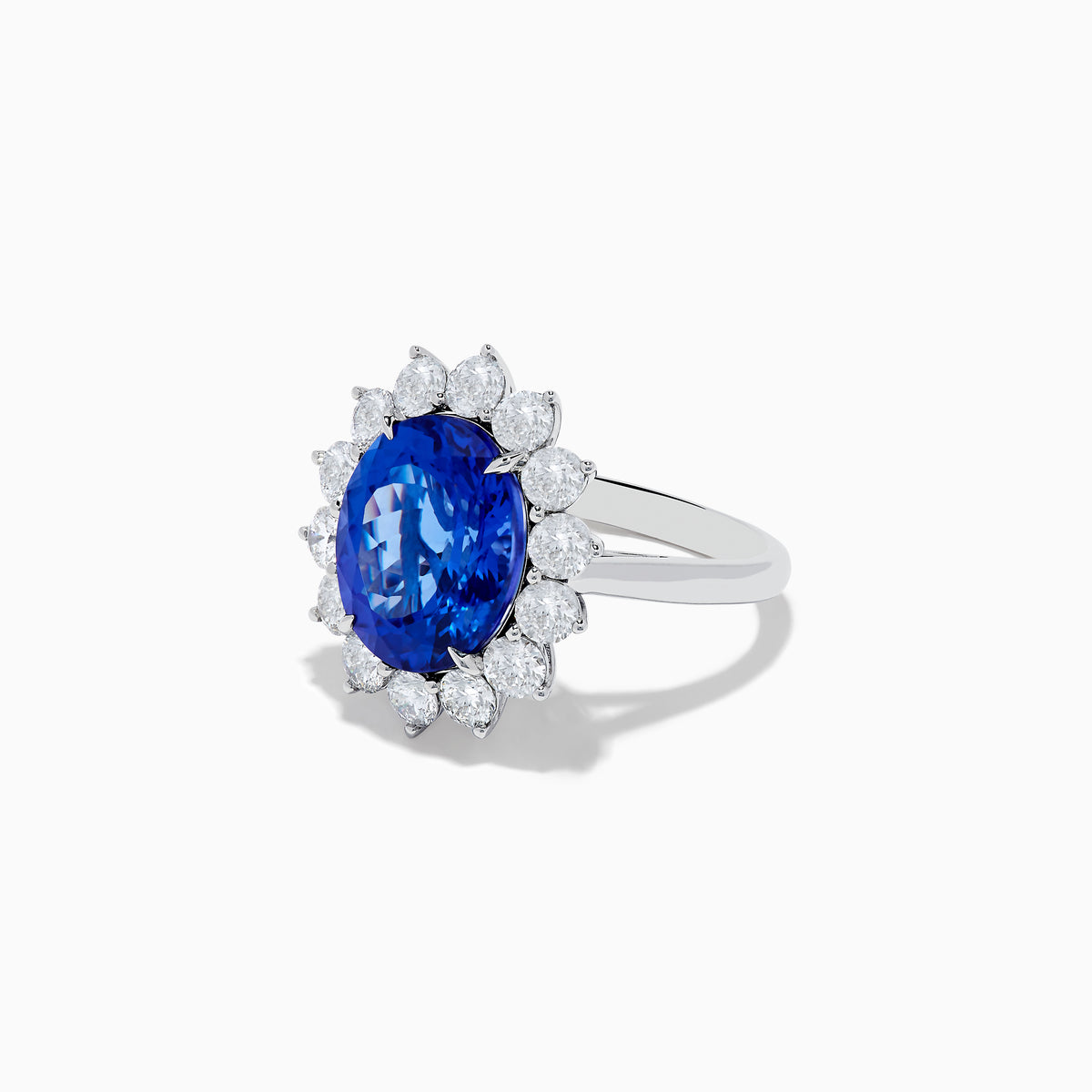 The Hematian 14K White Gold Tanzanite and Diamond Ring showcases a striking oval blue tanzanite center with a halo of round white diamonds, displayed on a plain white background.