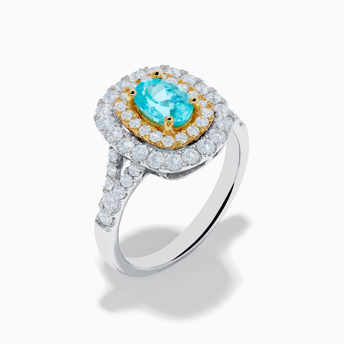 The 18K Two Tone Gold Paraiba and Diamond Double Halo Ring features an oval Paraiba centerpiece, surrounded by radiant yellow and white diamonds in a double halo, creating a striking layered effect.