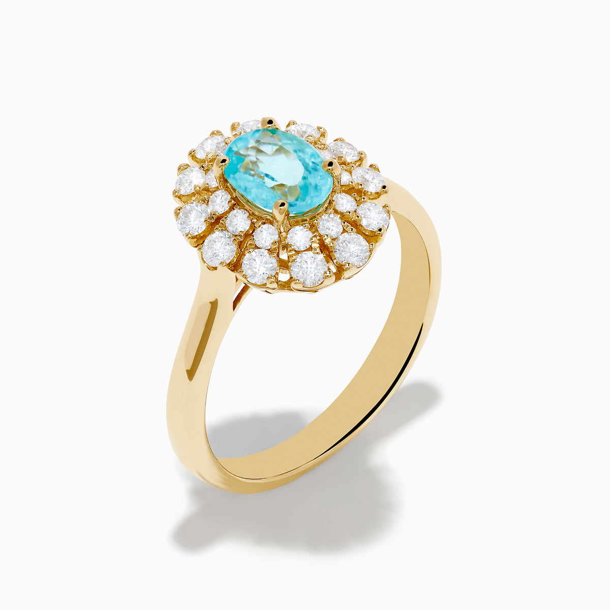 The 18K Yellow Gold Paraiba and Diamond Ring features an oval Paraiba gemstone at the center, encircled by a double halo of round diamonds, all showcased on a plain white background.