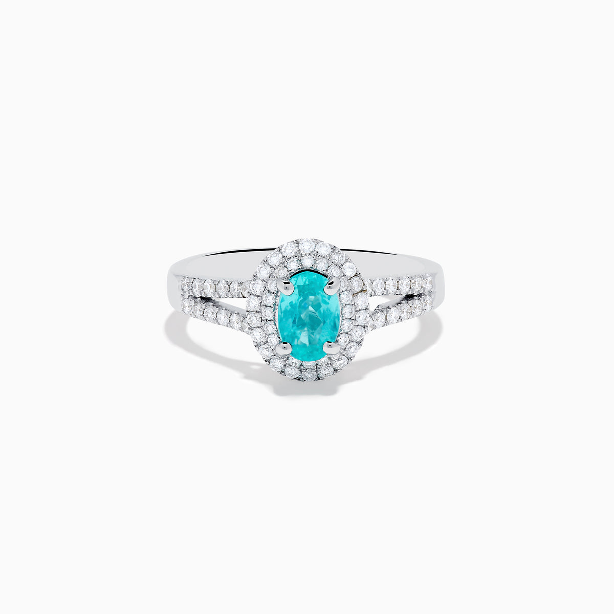 The 18K White Gold Paraiba and Diamond Ring showcases an oval Paraiba gemstone at the center, encircled by a halo of sparkling diamonds and accented with additional diamonds along its elegant split shank band.