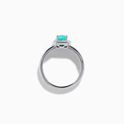 The 18K White Gold Paraiba and Diamond Halo Ring features an oval Paraiba center gemstone, encircled by sparkling diamonds and set on an elegant split shank band adorned with additional diamonds.