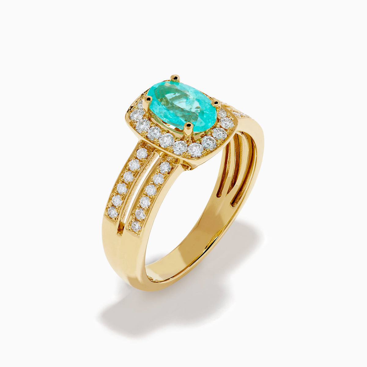 The 18K Yellow Gold Paraiba and Diamond Halo Ring showcases a central oval Paraiba turquoise, surrounded by a diamond halo and additional diamonds on the split shank band, all set in yellow gold and shown against a white background.