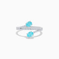 The 18K White Gold Paraiba and Diamond Bypass Ring features two oval Paraiba gemstones at each end of an open band, accented with small sparkling diamonds along the upper surface.