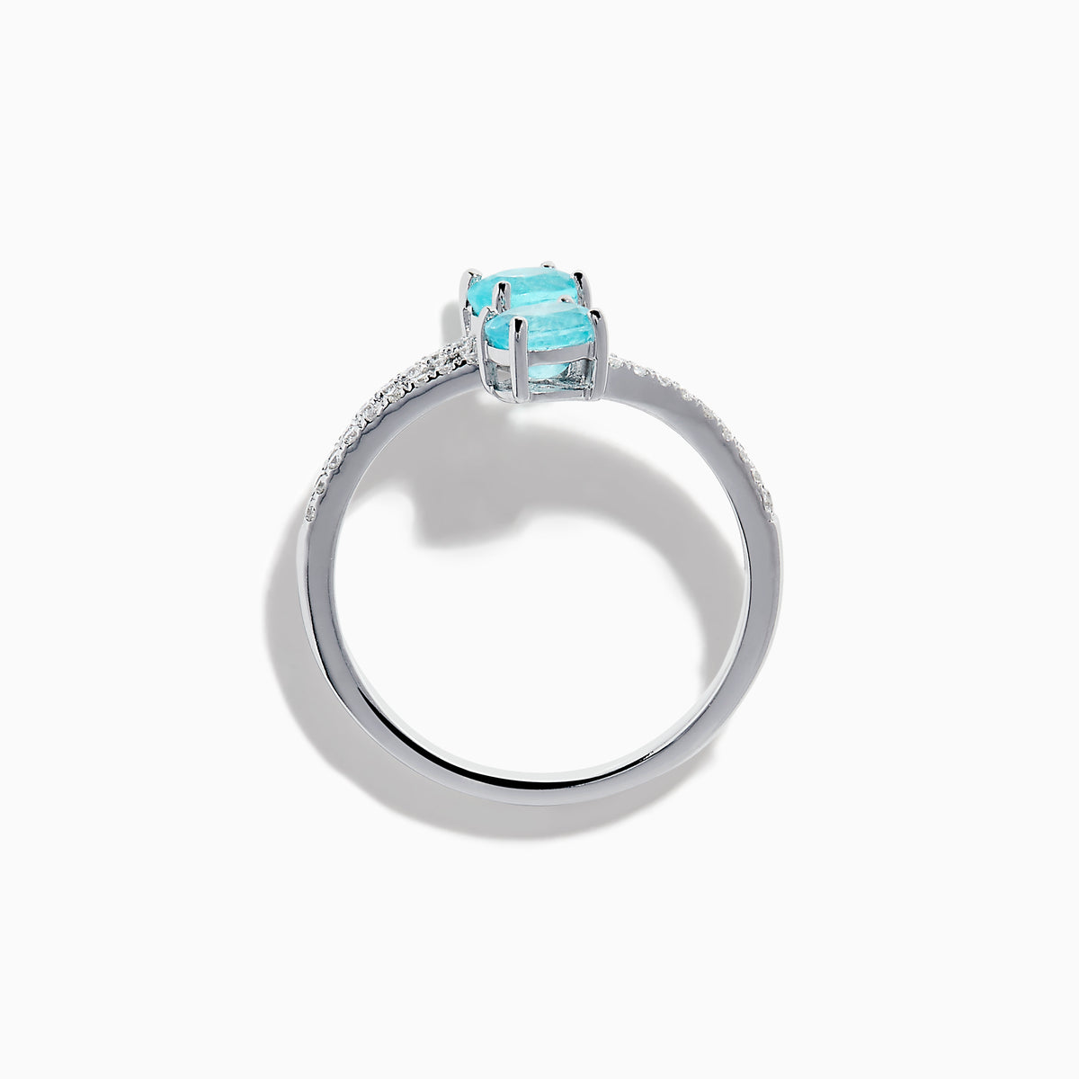 The 18K White Gold Paraiba and Diamond Bypass Ring features two oval Paraiba gemstones at each end of an open band, accented with small sparkling diamonds along the upper surface.
