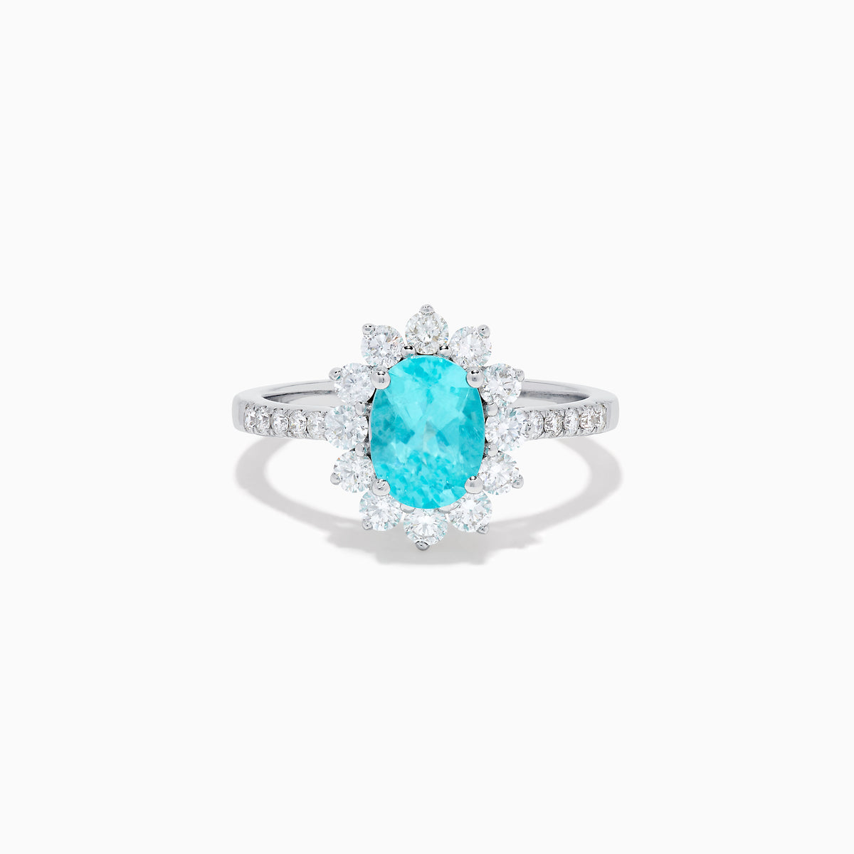 The 14K White Gold Paraiba and Diamond Halo Ring showcases an oval-shaped Paraiba gemstone at the center, encircled by a sparkling diamond halo with additional diamonds adorning the band.