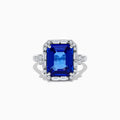 The Nahla Siri 14K White Gold Emerald Cut Tanzanite and Diamond Ring features a large emerald-cut tanzanite center, accented by baguette and round diamonds, displayed on a white background.
