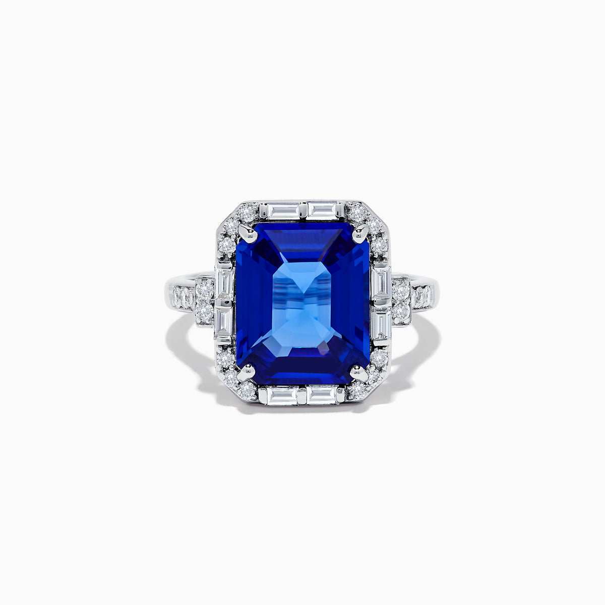 The Nahla Siri 14K White Gold Emerald Cut Tanzanite and Diamond Ring features a large emerald-cut tanzanite center, accented by baguette and round diamonds, displayed on a white background.