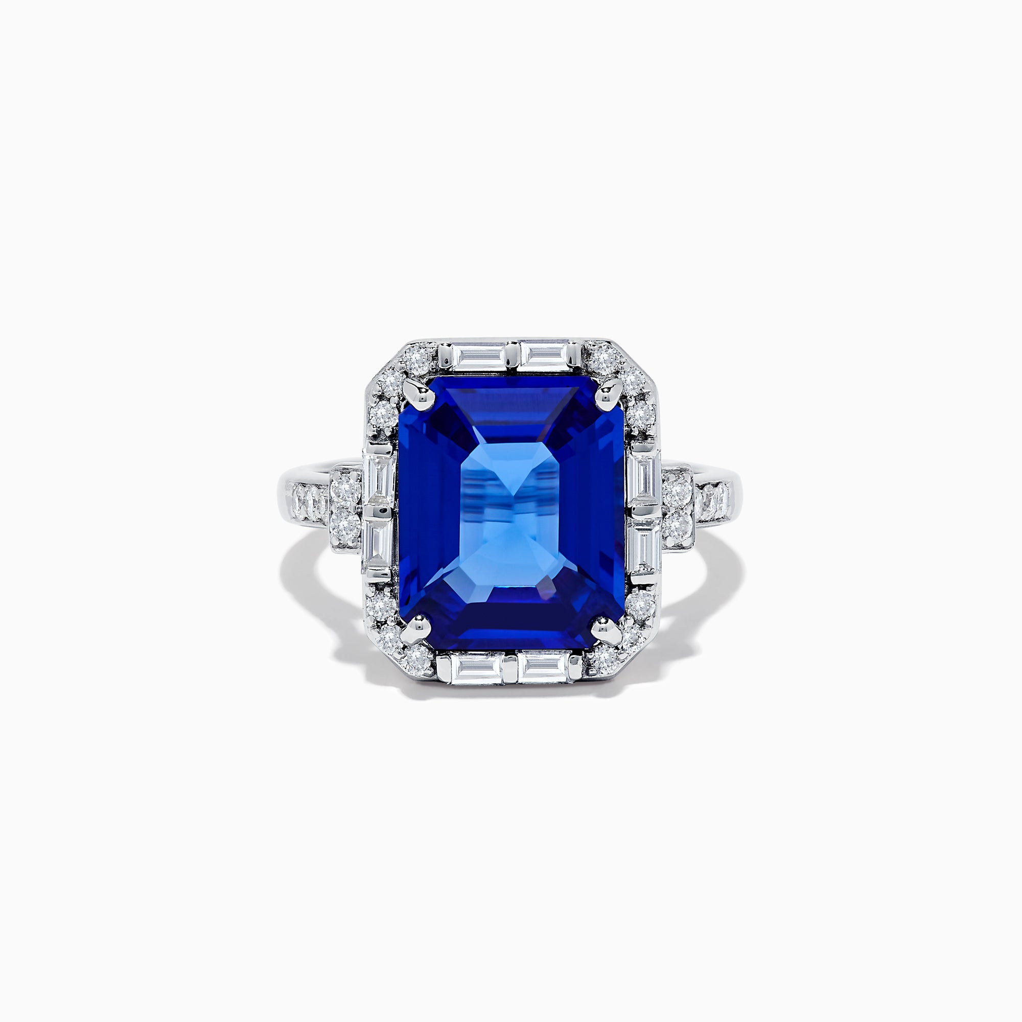 The Nahla Siri 14K White Gold Emerald Cut Tanzanite and Diamond Ring features a large emerald-cut tanzanite center, accented by baguette and round diamonds, displayed on a white background.