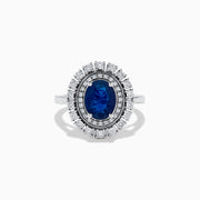 The 14K White Gold Blue Sapphire and Diamond Double Halo Ring features an oval blue sapphire surrounded by two halos of round white diamonds on a white gold band, shown against a white background.