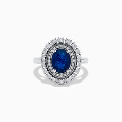 The 14K White Gold Blue Sapphire and Diamond Double Halo Ring features an oval blue sapphire surrounded by two halos of round white diamonds on a white gold band, shown against a white background.