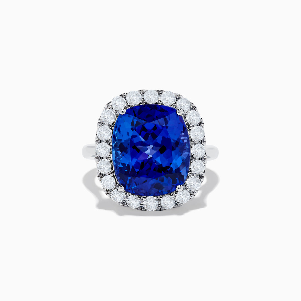 The Nahla Siri 14K White Gold Tanzanite and Diamond Ring showcases a large cushion-cut blue tanzanite center, encircled by a halo of round white diamonds, shown on a white background.