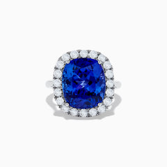 The Nahla Siri 14K White Gold Tanzanite and Diamond Ring showcases a large cushion-cut blue tanzanite center, encircled by a halo of round white diamonds, shown on a white background.