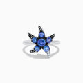 The 925 Sterling Silver Tanzanite and Diamond Starfish Ring features five round tanzanite gemstones and sparkling diamonds along one arm, displayed on a white background.