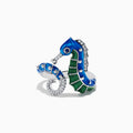The Seaside 14K White Gold Blue Sapphire and Diamond Seahorse Ring features two seahorses with blue and green enamel details and sparkling gemstones, shown against a white background.
