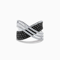 The 14K White Gold White and Black Diamond Criss Cross Ring features an overlapping wide band with alternating rows of black and white diamonds set in polished white gold.