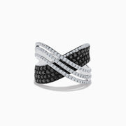 The 14K White Gold White and Black Diamond Criss Cross Ring features an overlapping wide band with alternating rows of black and white diamonds set in polished white gold.