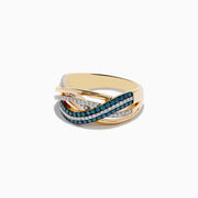 The Bella Bleu 14K Yellow Gold Blue and White Diamond Crossover Ring features intertwining bands set with blue and white diamonds, creating an elegant wavy design against a white background.