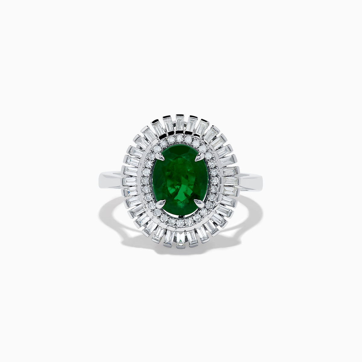 The 14K White Gold Emerald and Diamond Ring features an oval emerald center accented by two rows of baguette and round diamonds in a radiant halo design.