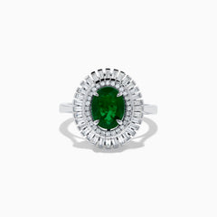 The 14K White Gold Emerald and Diamond Ring features an oval emerald center accented by two rows of baguette and round diamonds in a radiant halo design.