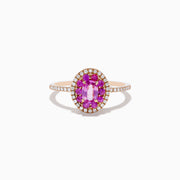 The 14K Rose Gold Pink Sapphire and Diamond Double Halo Ring features an oval pink sapphire center, double halo of clear diamonds, and a slim band with additional diamonds, shown on a white background.