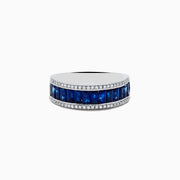 The Royale Bleu 14K White Gold Blue Sapphire and Diamond Ring showcases a central row of rectangular blue sapphires bordered by rows of sparkling diamonds, set against a white background.